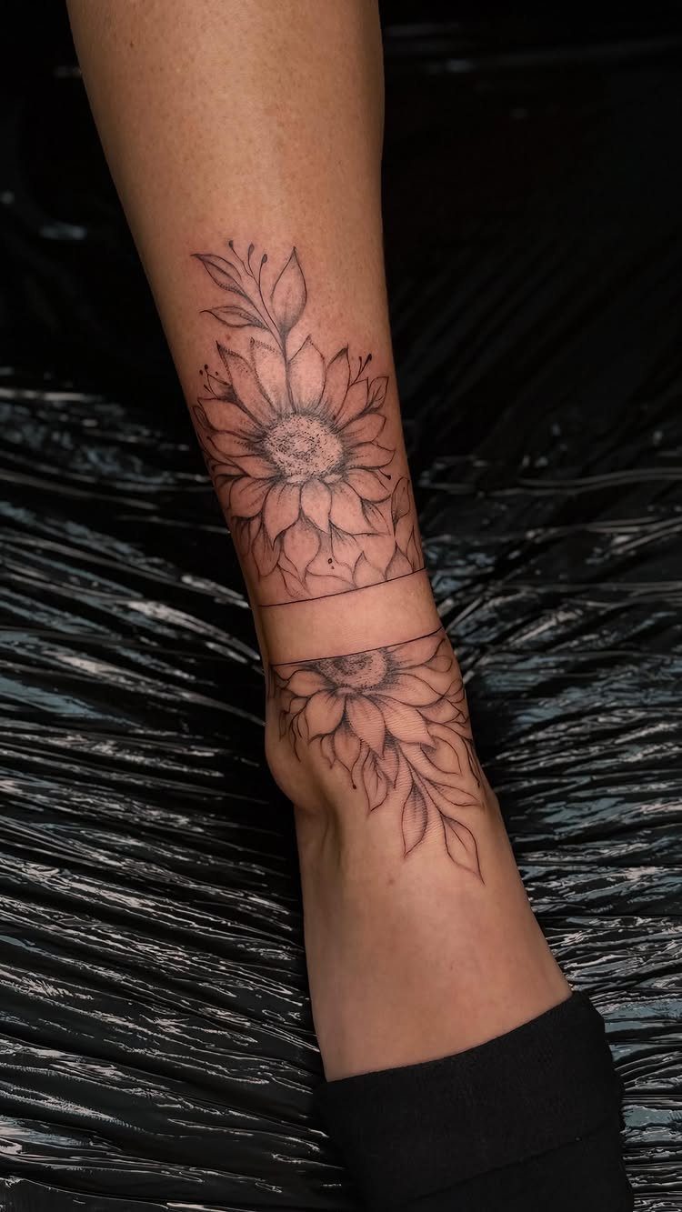 Sunflower tattoo with leaves on a person's ankle and lower leg.