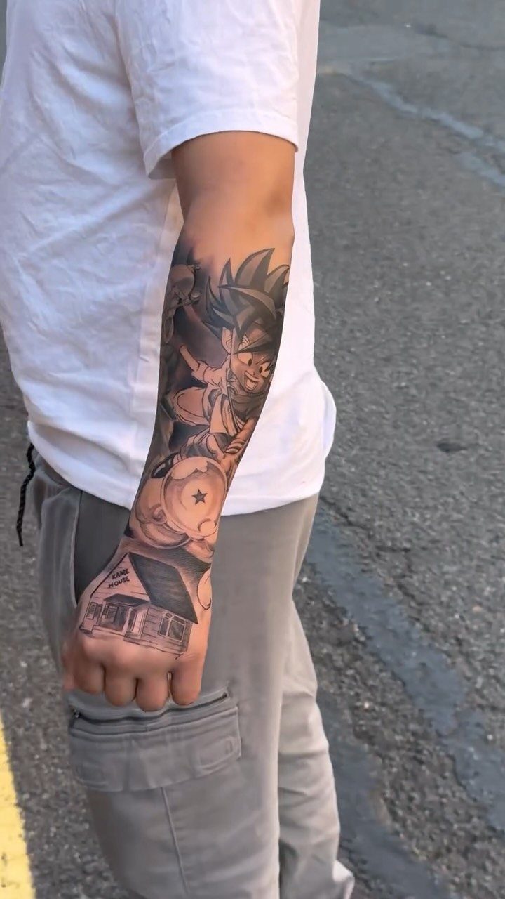 Anime character tattoo covering the forearm of a person in a white shirt.