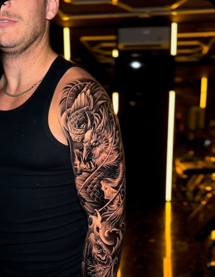 Man's arm featuring a detailed Japanese style dragon tattoo sleeve in black and gray.