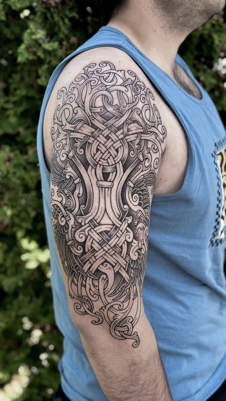 Viking sleeve tattoo with intricate black knotwork and Norse patterns on an upper arm.