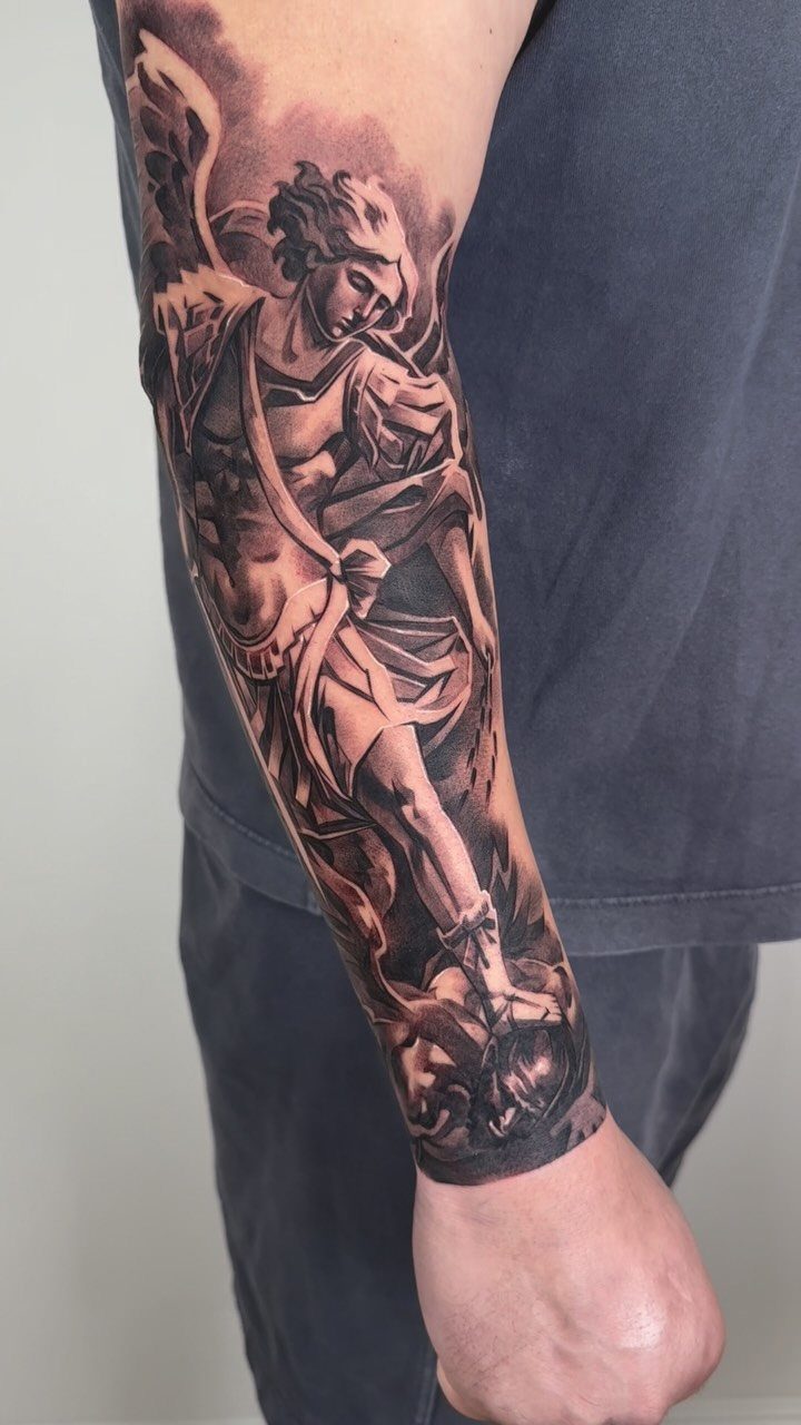 Classical figure tattoo in black and grey ink on the back of an arm