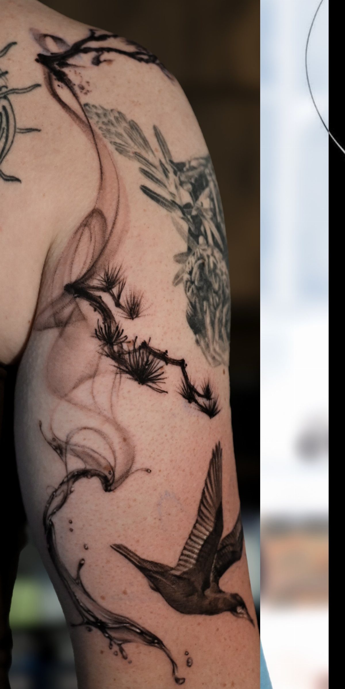 Tattoos of a bird and pine branches on the back of an arm.
