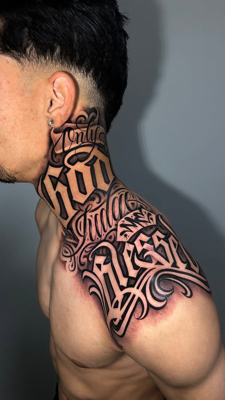 Intricate black and grey lettering tattoo on a man's neck and shoulder.