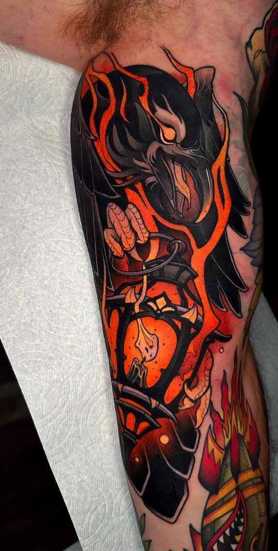 Neo-traditional tattoo of a black raven and glowing orange lantern on an arm
