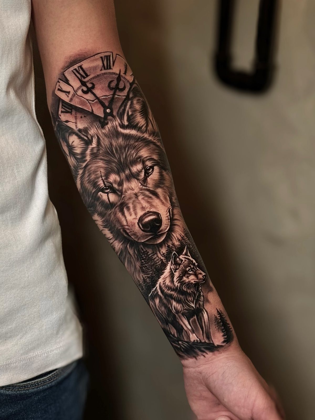 Detailed black and grey wolf and clock tattoo on a man's forearm