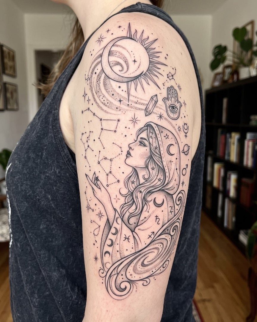 Celestial bicep tattoo featuring a moon, sun, stars, and a woman's profile.