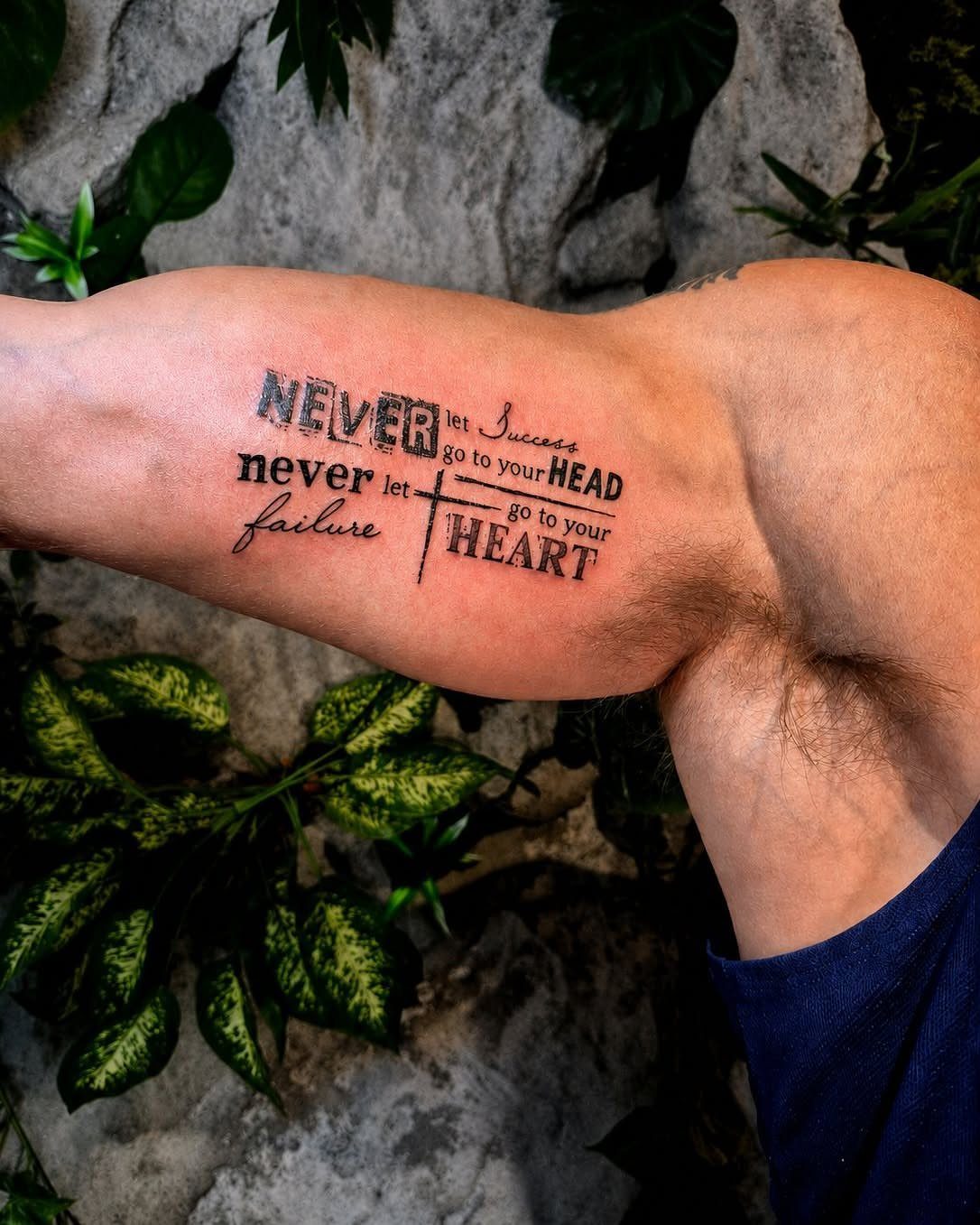 Inner bicep tattoo with inspirational quote about success and failure in black ink