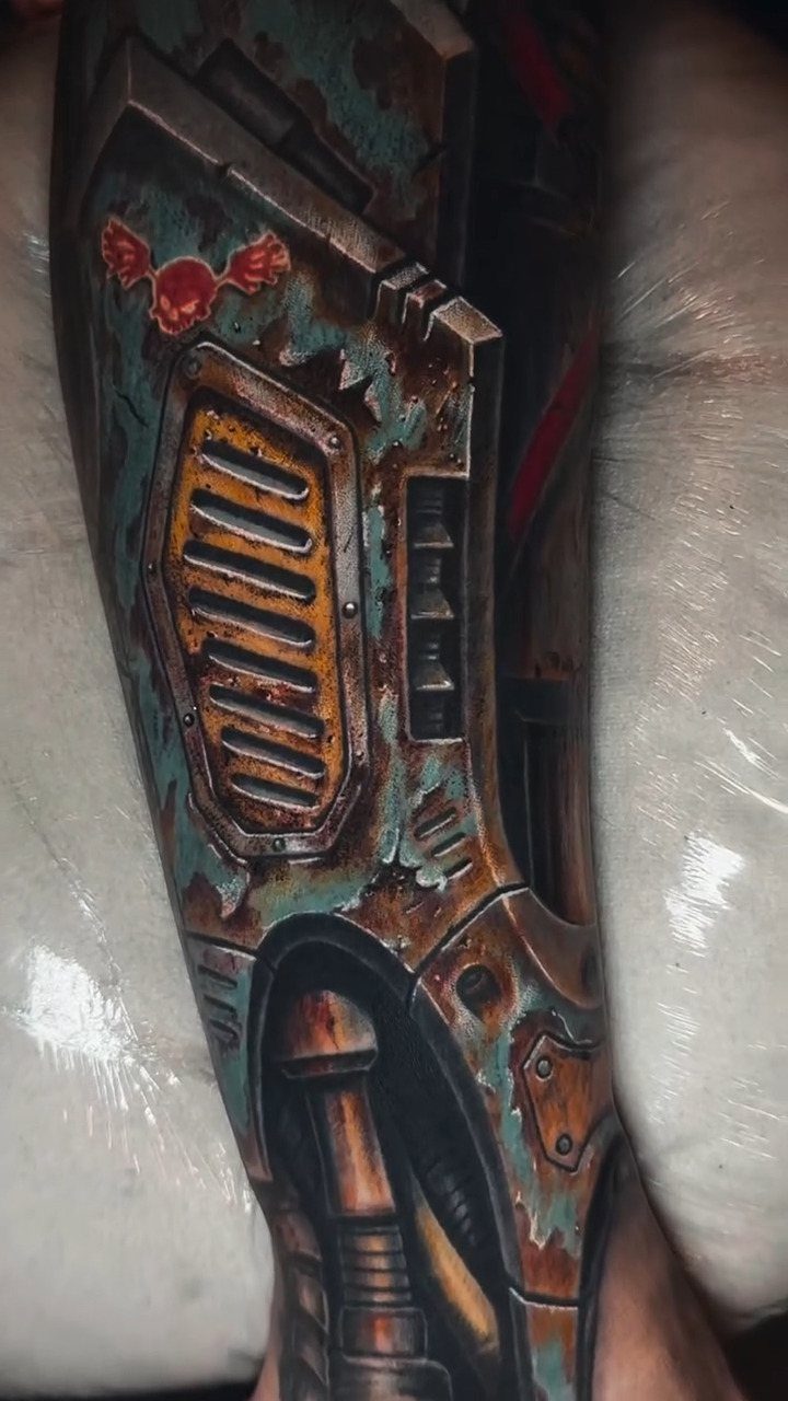 Biomechanical tattoo on a leg showing rusted metal plates and internal machinery components.