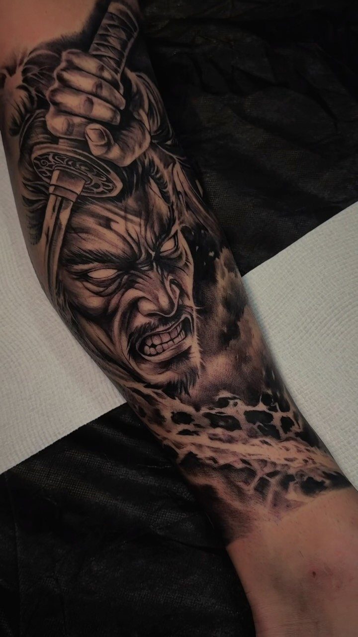 Samurai warrior tattoo on a calf featuring a fierce face and a katana sword.