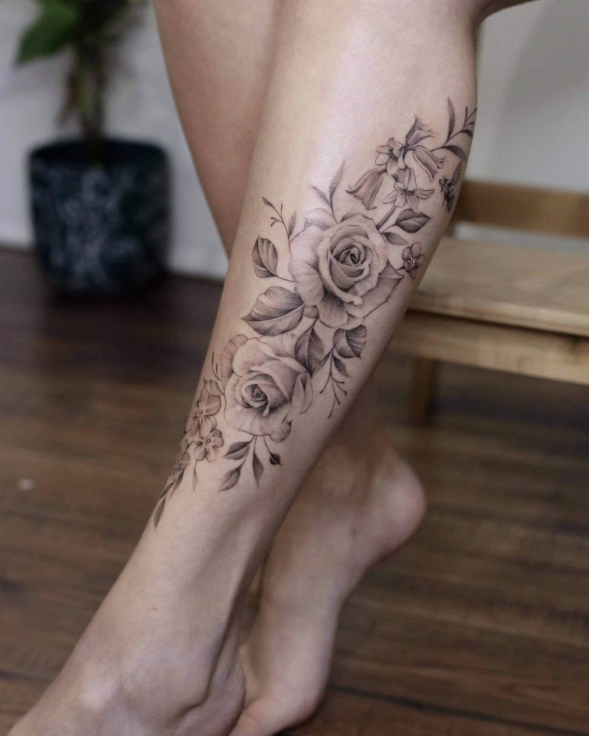 Rose and leaf blackwork tattoo on a person's lower leg and calf
