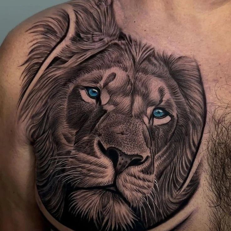 Lion head tattoo with blue eyes on a man's chest