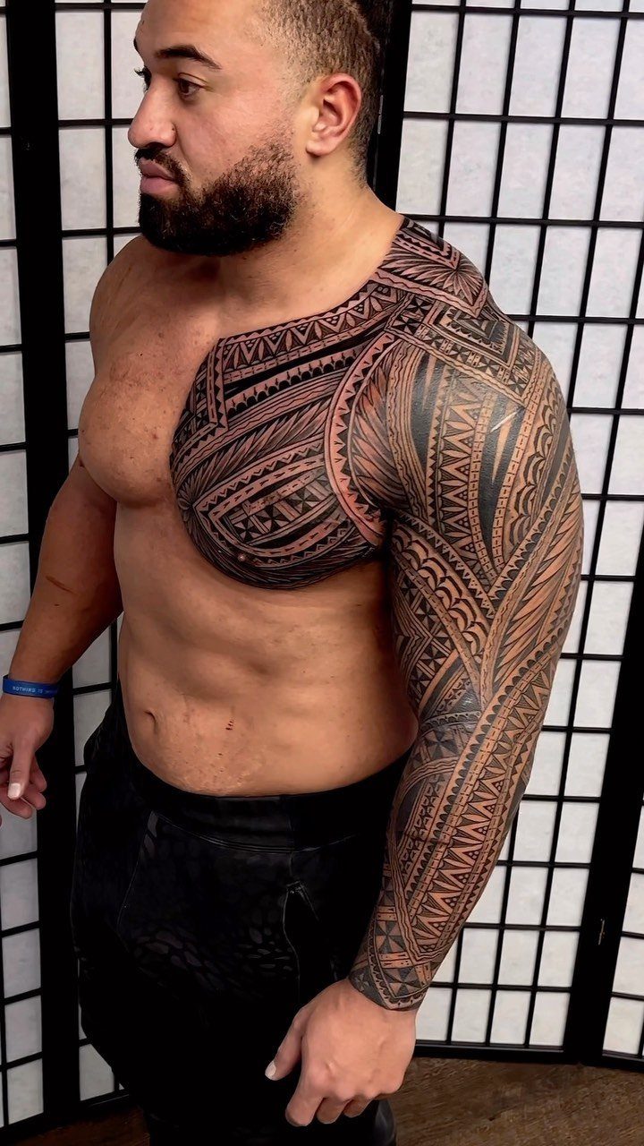 Muscular man with a large tribal tattoo on his chest and arm.