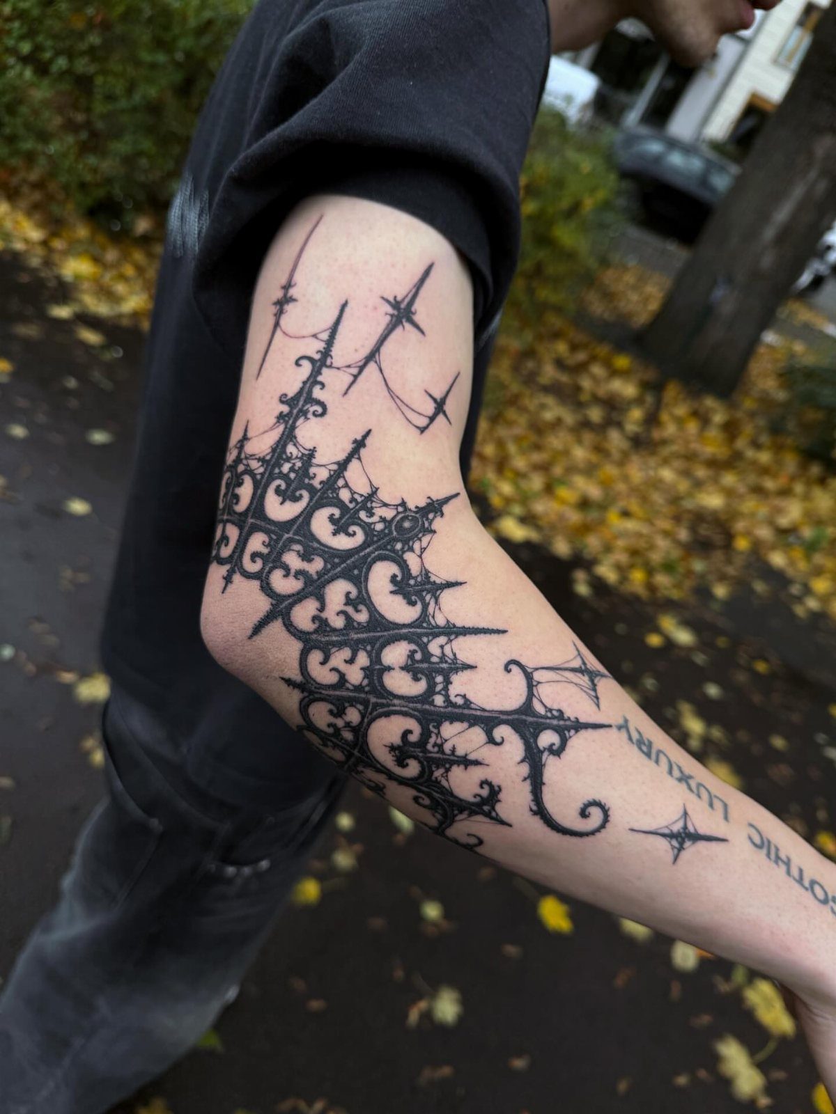 Gothic cathedral architecture tattoo on a person's elbow and forearm in black ink.
