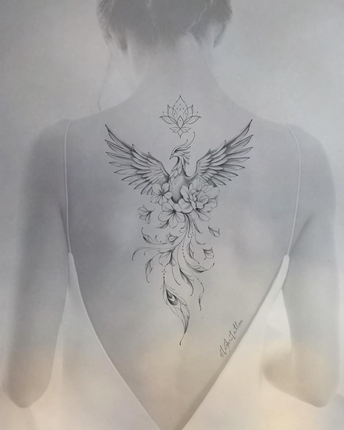 Phoenix tattoo with wings and flowers centered on a woman's back