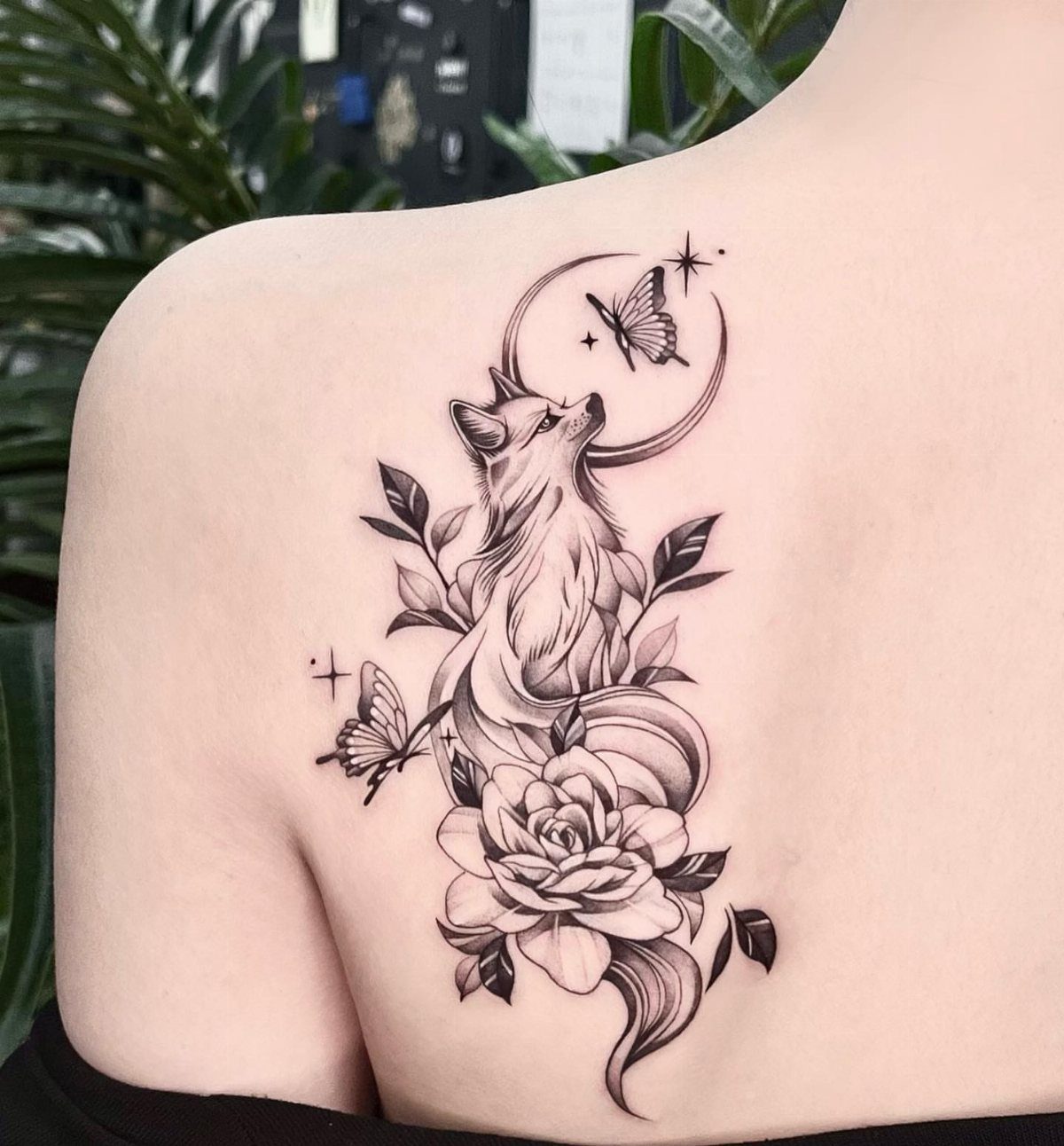 Fox and butterfly tattoo with a rose and crescent moon on a shoulder