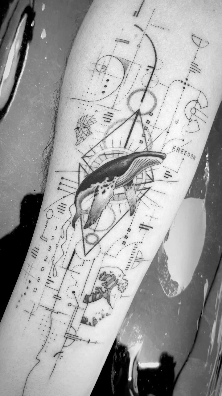 Whale tattoo with geometric circles and lines on a person's forearm.