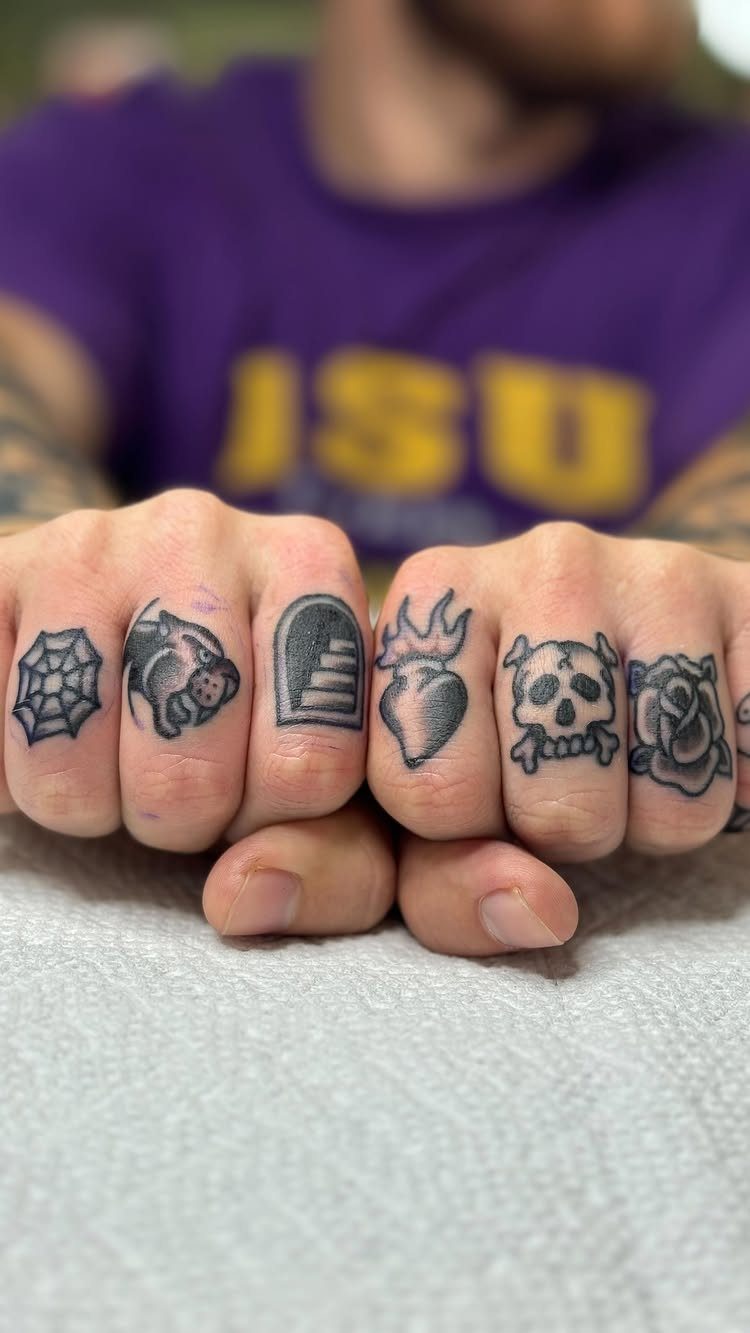 Knuckle tattoos featuring a spider web, pig, stairs, flaming heart, skull, and rose.
