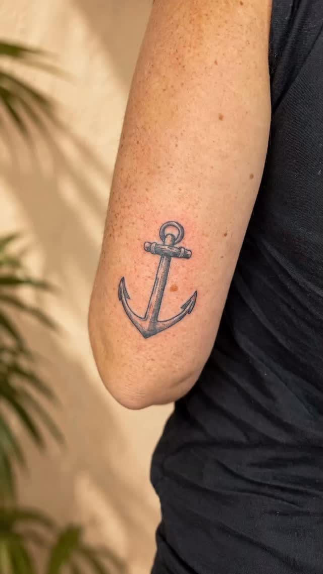 Anchor tattoo on a person's forearm with blue-black ink and clean lines.