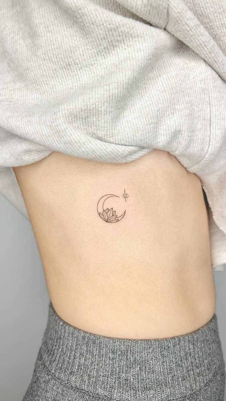 Crescent moon tattoo with a small star on a person's side torso.