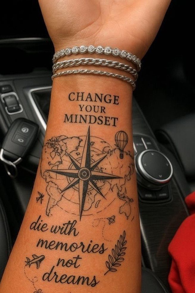 Forearm tattoos with motivational quotes, a compass, and a world map.