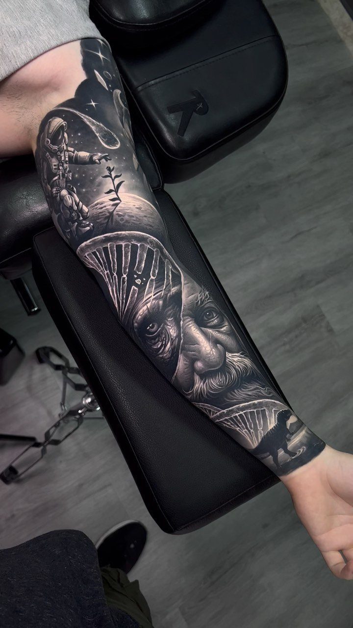 Full sleeve tattoo on a man's arm featuring a realistic elderly man's portrait.