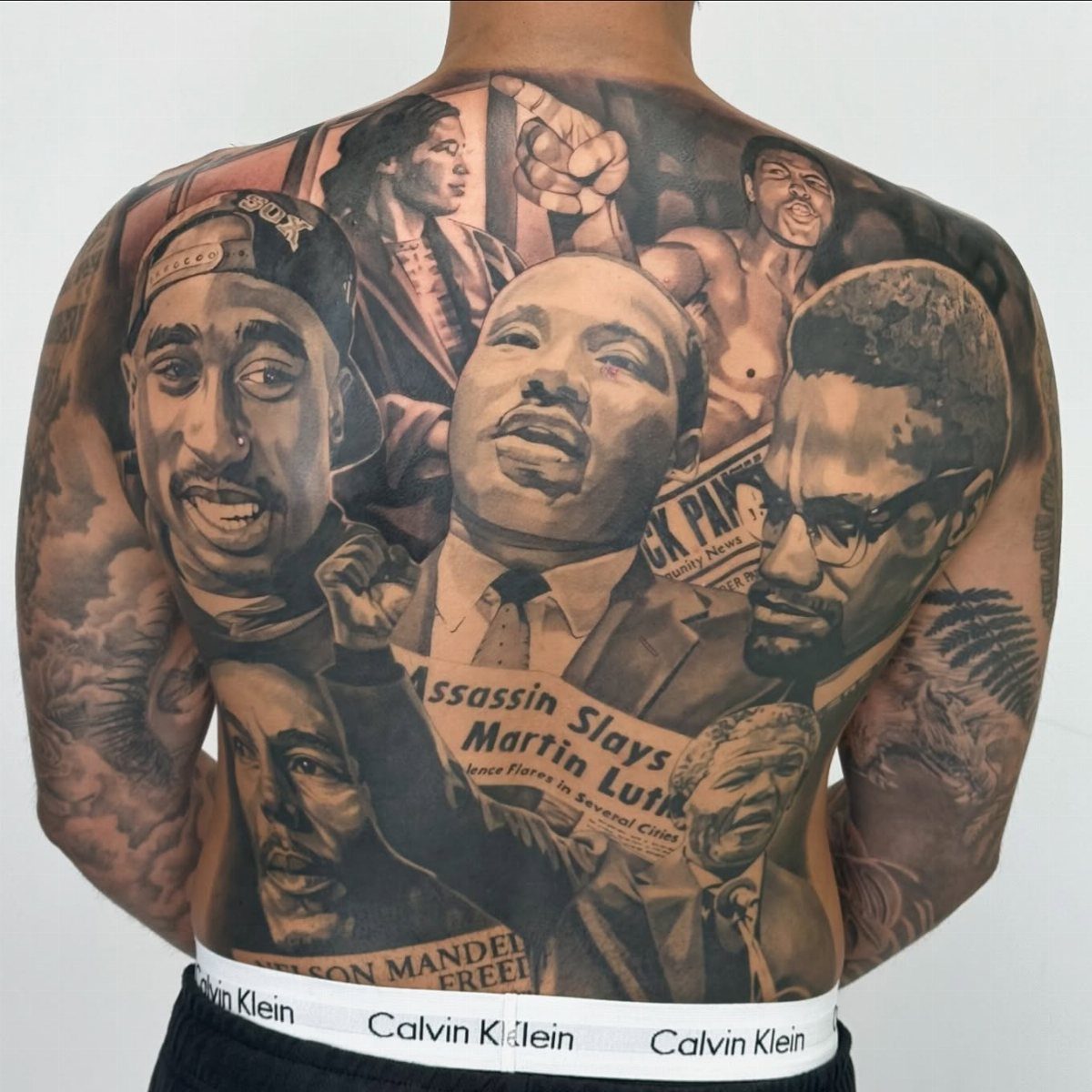 Full back tattoo featuring realistic portraits of influential Black historical and cultural figures.
