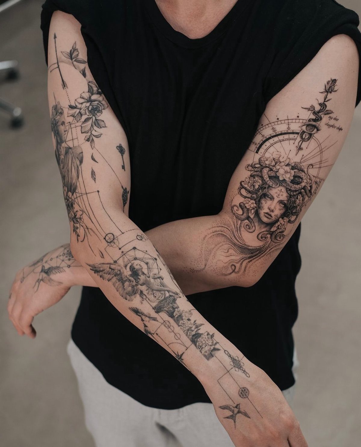 Detailed fine line sleeve tattoos on a person's arms featuring figures and florals