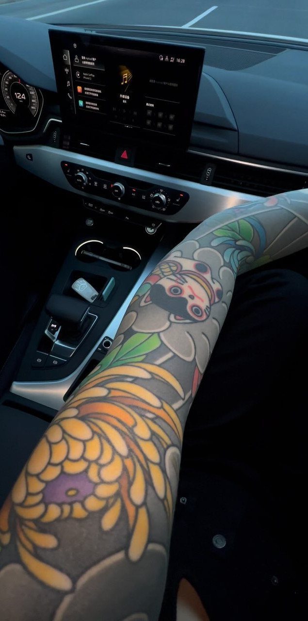 Full sleeve Irezumi tattoo with koi fish and yellow flowers on a man's arm.