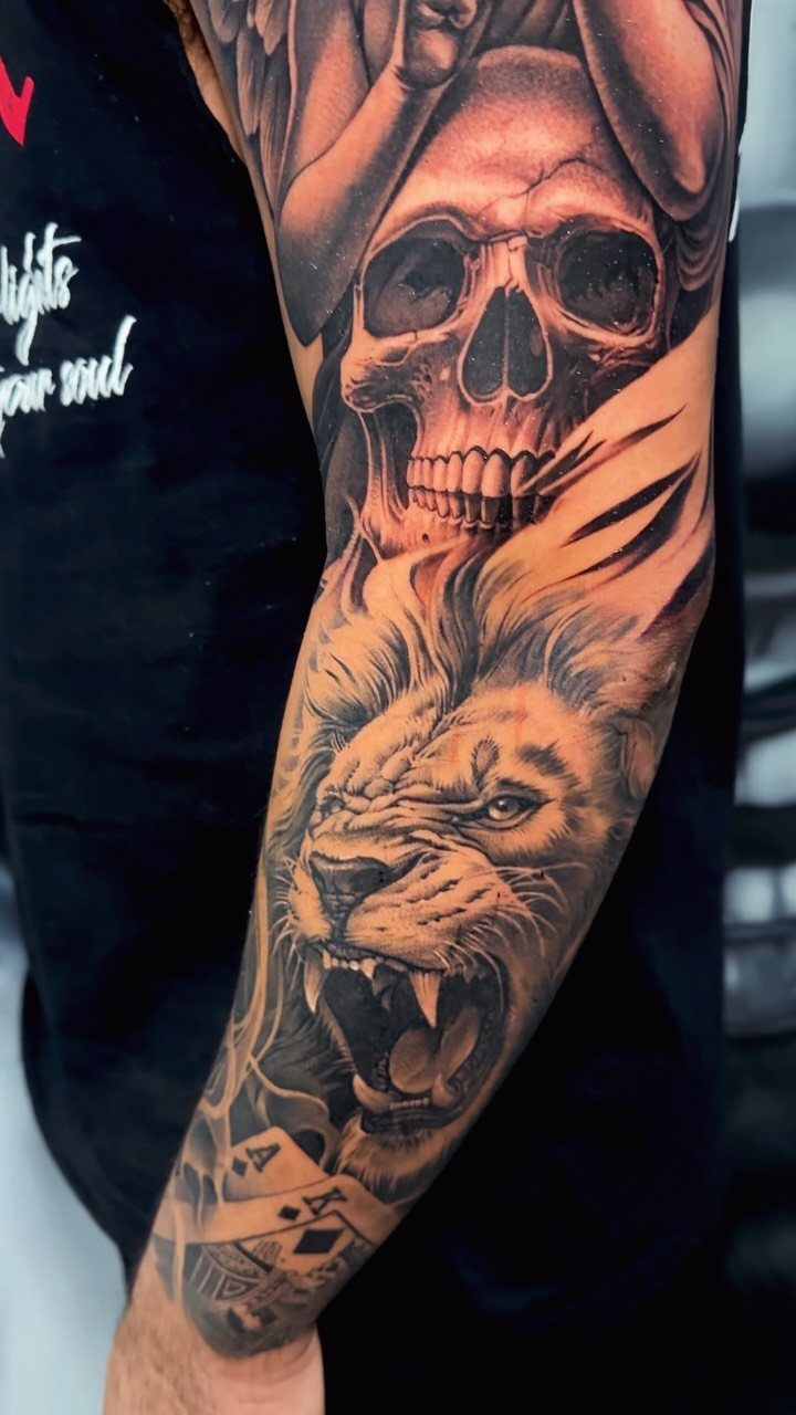 Roaring lion and skull realism sleeve tattoo on a man's arm.