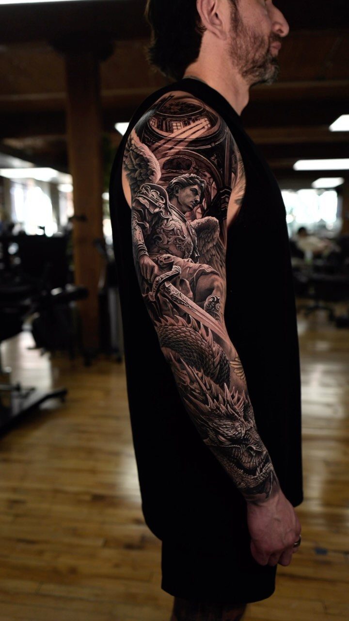 Full sleeve tattoo of an angel and architecture on a man's arm