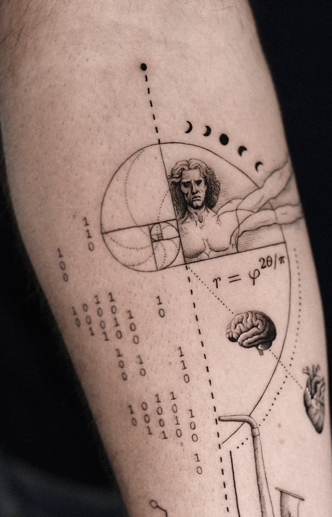 Fibonacci spiral tattoo on an arm with a portrait, brain, and mathematical symbols.