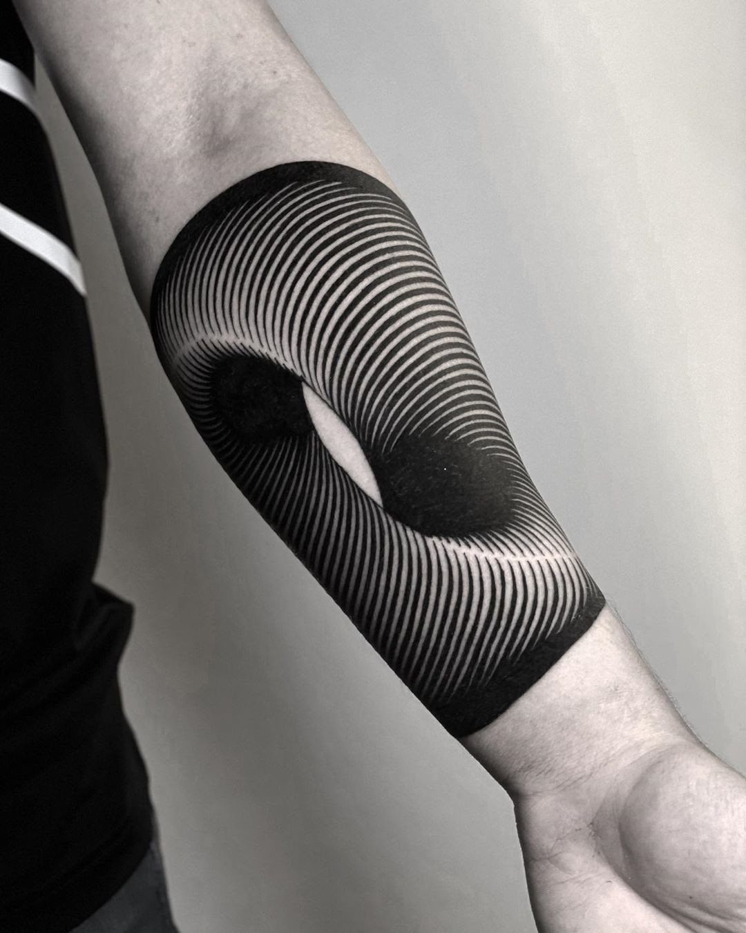 Geometric forearm tattoo with black curving lines creating a 3D optical illusion hole.
