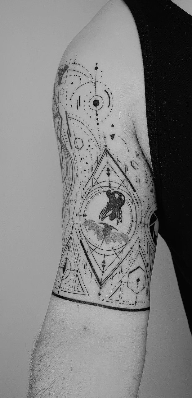 Geometric half sleeve tattoo on a man's arm with symmetrical patterns and circles.