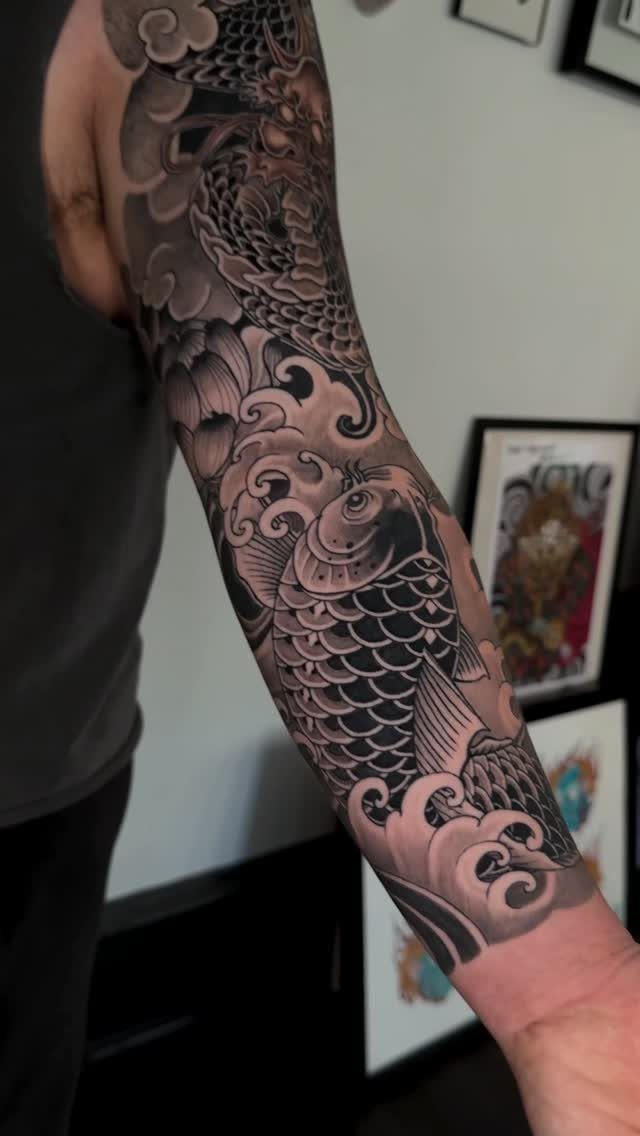 Half sleeve tattoo featuring a koi fish and dragon in Japanese Irezumi style.