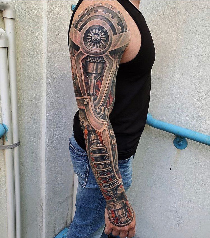 Biomechanical tattoo on a man's arm showing gears and pistons under the skin.