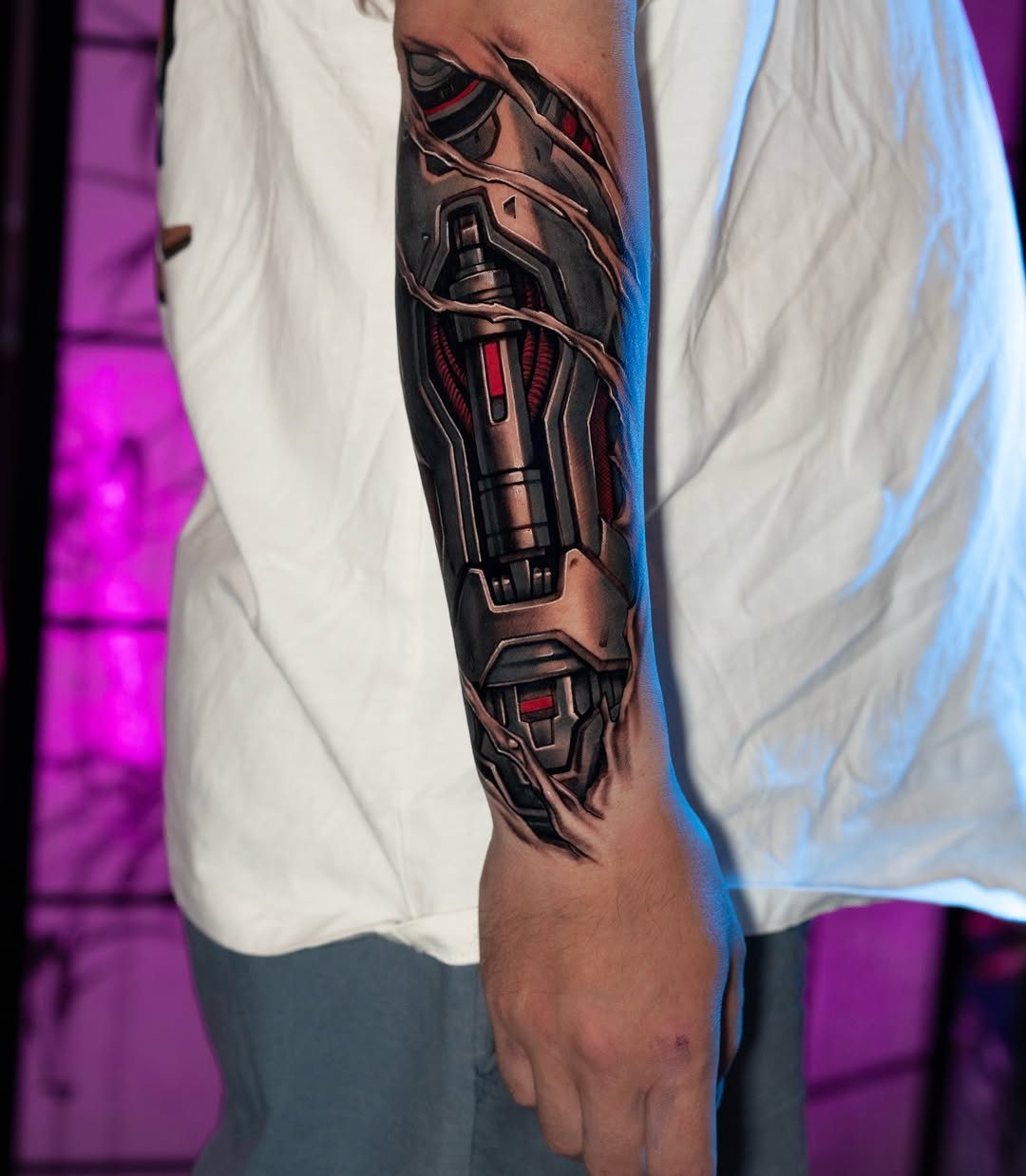Biomechanical tattoo on a forearm depicting metallic robotic parts and machinery under skin.