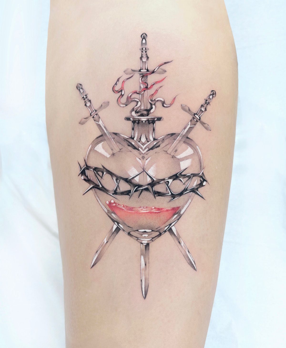 Transparent heart tattoo pierced by three swords and wrapped in black barbed wire