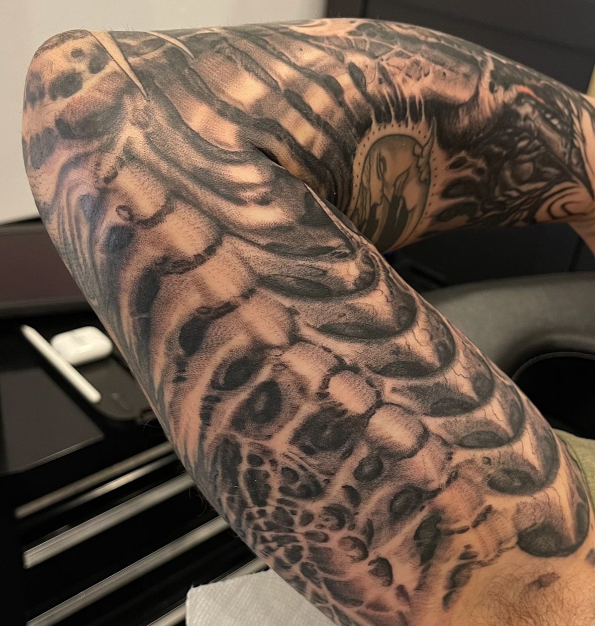 Inner arm with a bold blackwork tattoo featuring flowing organic shapes and shading.