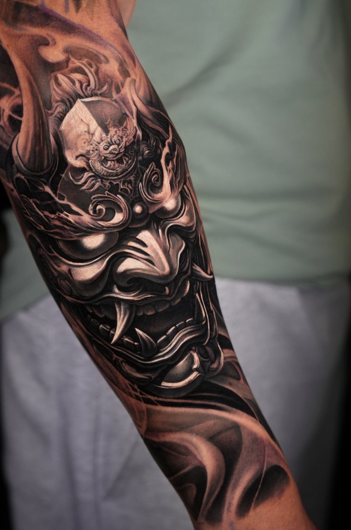 Japanese Hannya mask tattoo with fangs and smoke on a man's arm