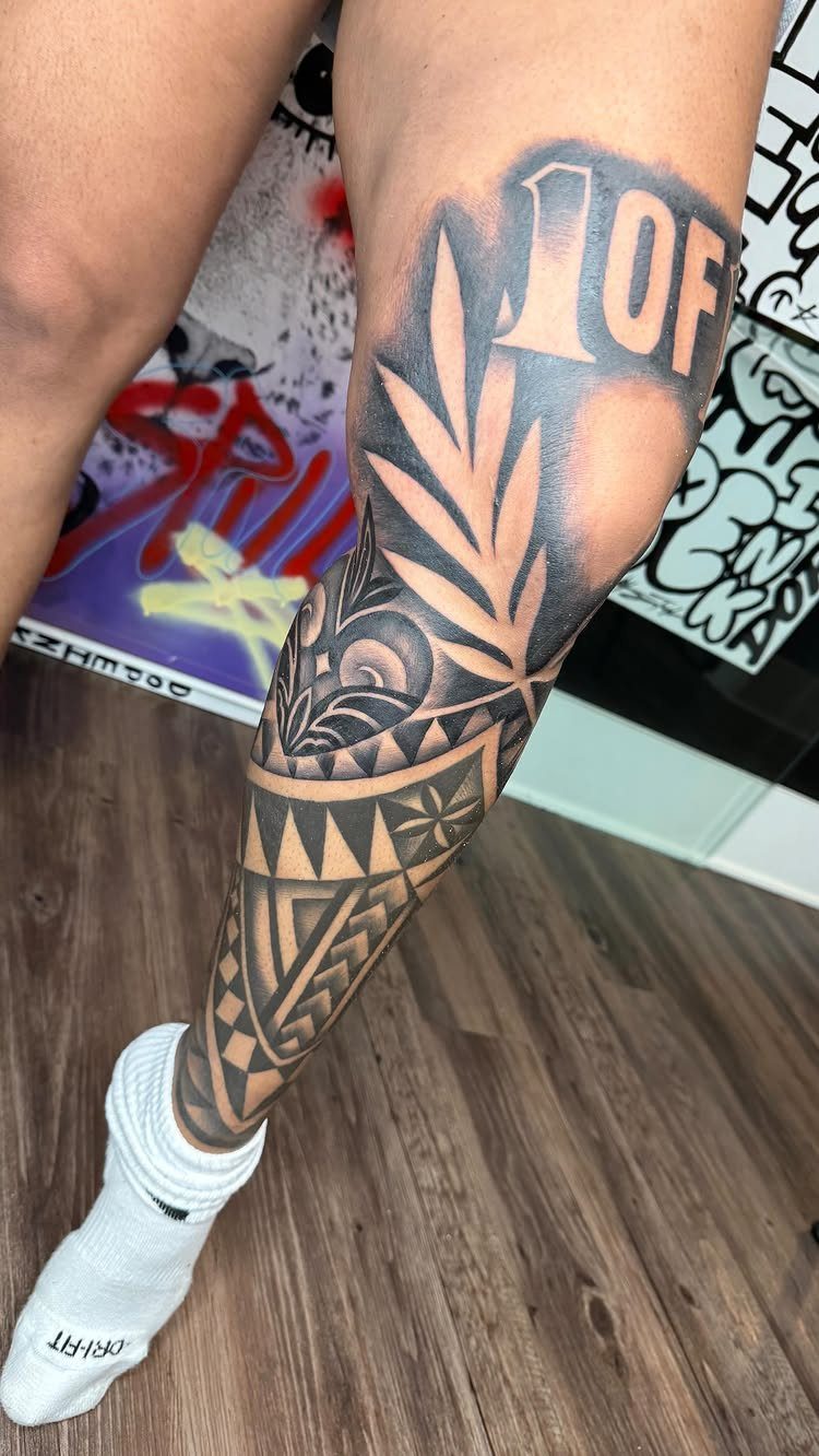 Lower leg with a black and grey geometric and leaf tattoo design