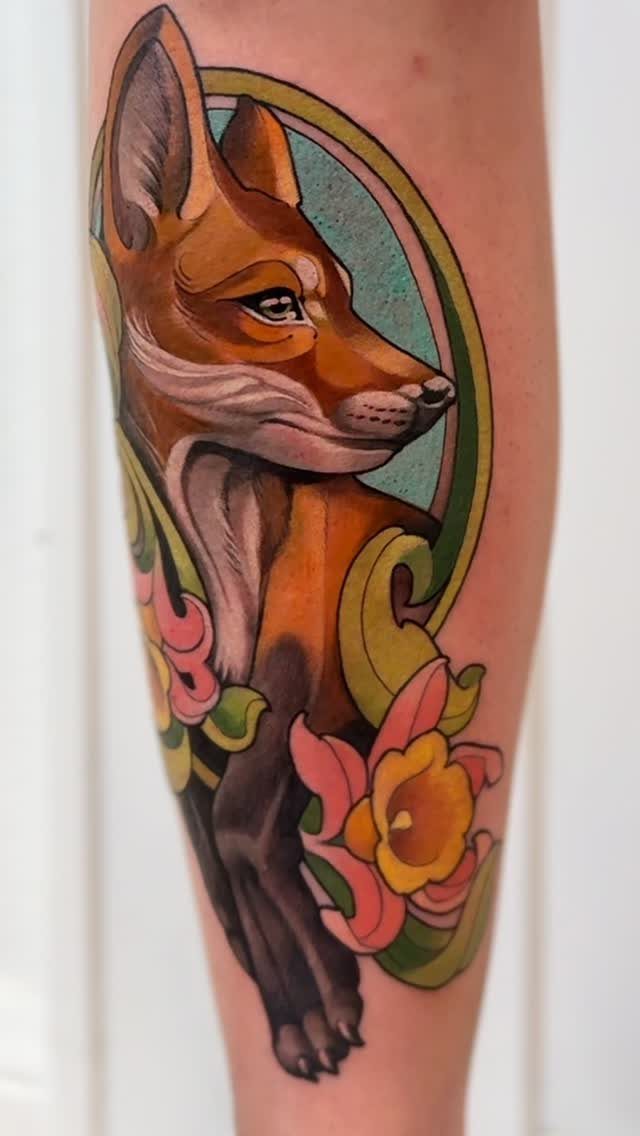 Stylized orange fox tattoo with pink flowers on a person's leg