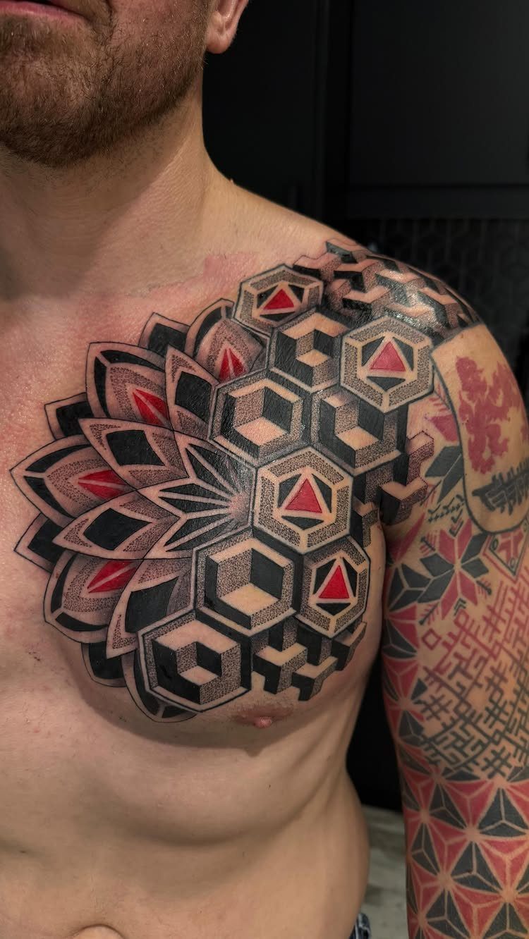 Geometric mandala tattoo with 3D cubes on a man's chest and shoulder