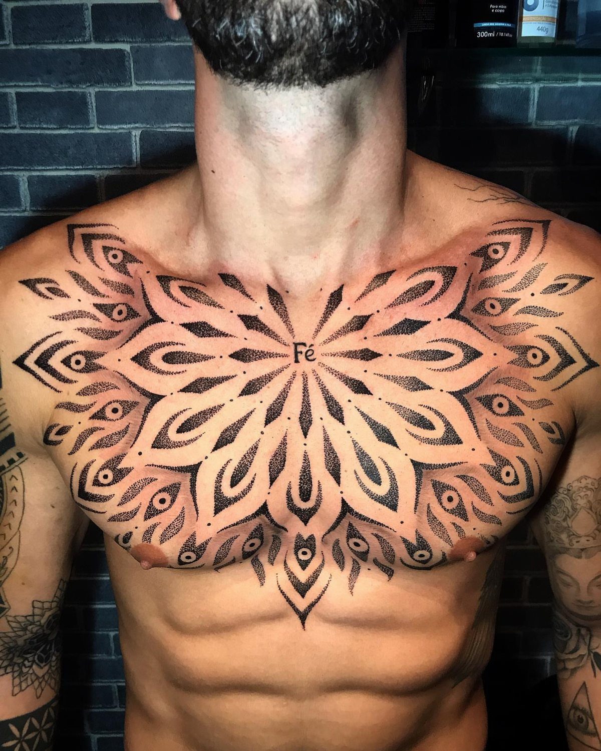 Large black ink mandala tattoo centered on a man's chest and sternum