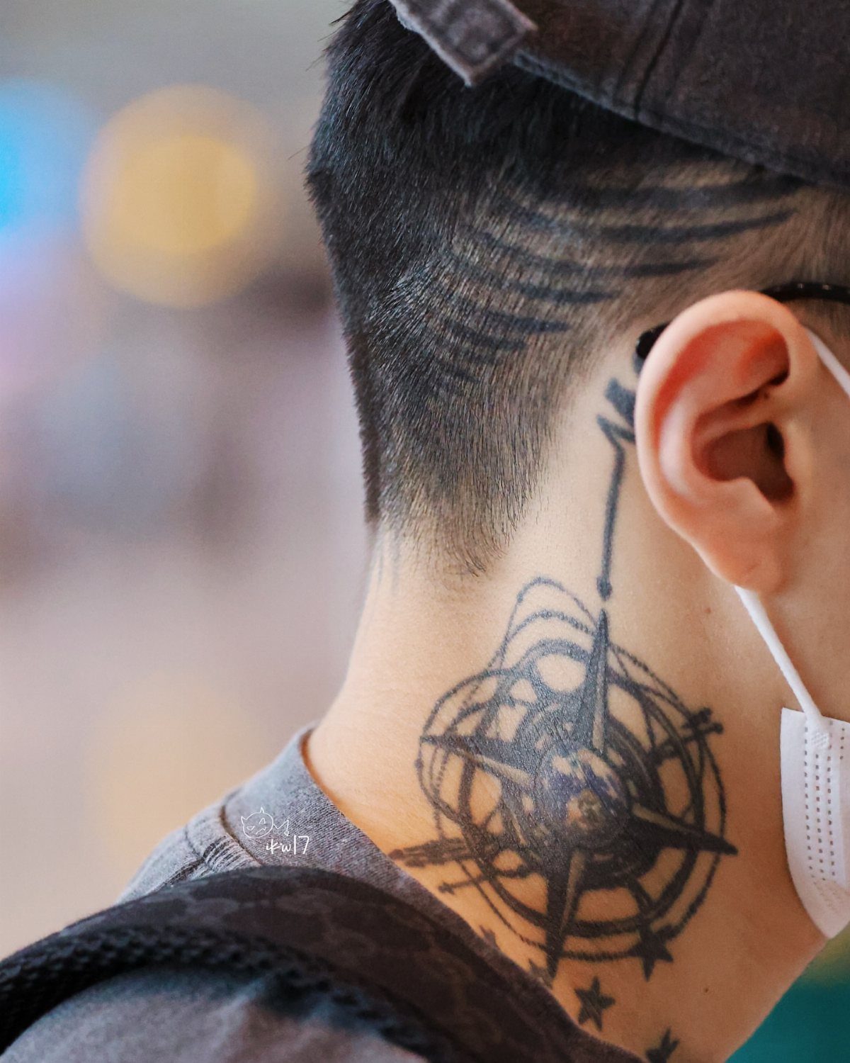 Compass tattoo on a man's neck with stars and a directional needle.