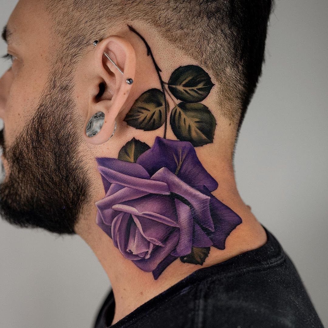 Purple rose tattoo on the side of a man's neck with green leaves.