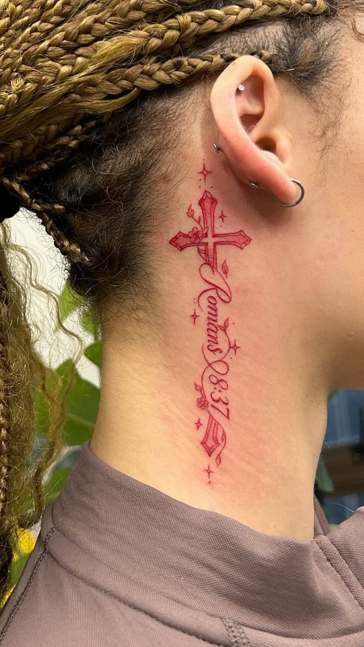 Red cross tattoo with Romans 8:37 scripture on a person's side neck.