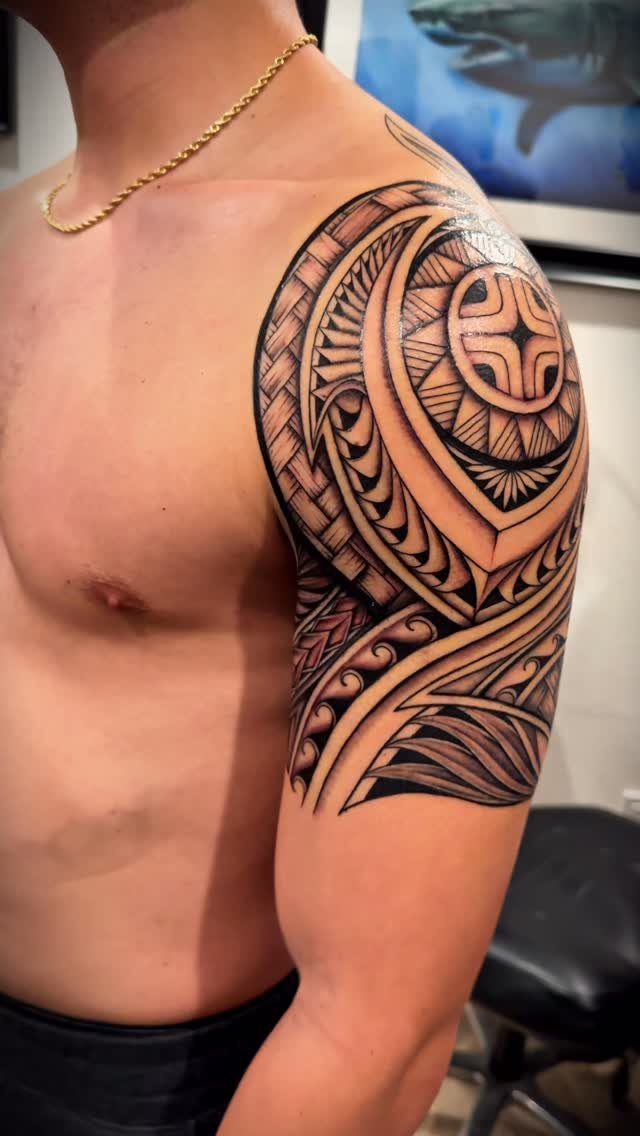 Polynesian style tattoo on a man's shoulder and upper arm with geometric patterns