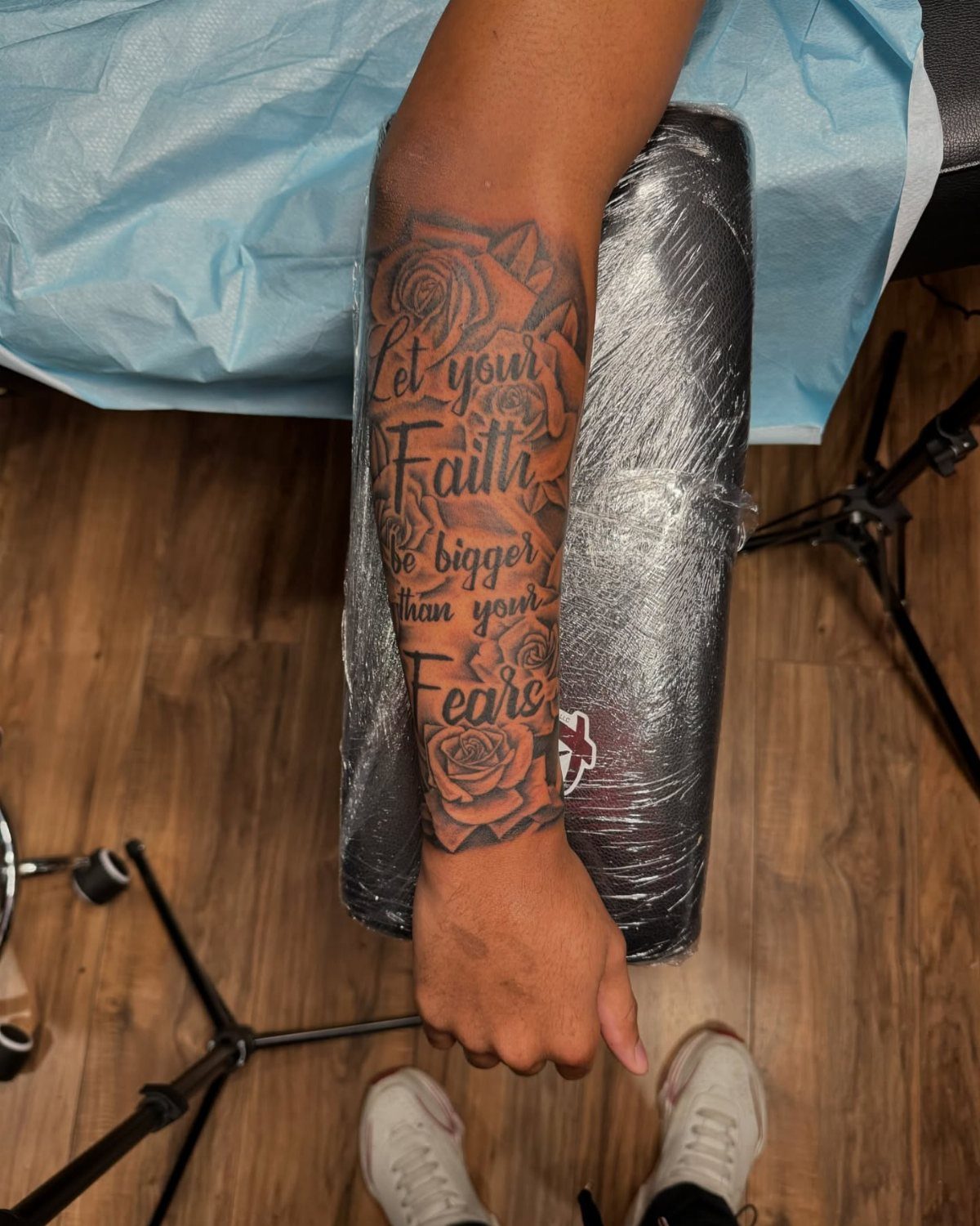 Forearm tattoo with roses and script text reading Let your Faith be bigger than your Fears