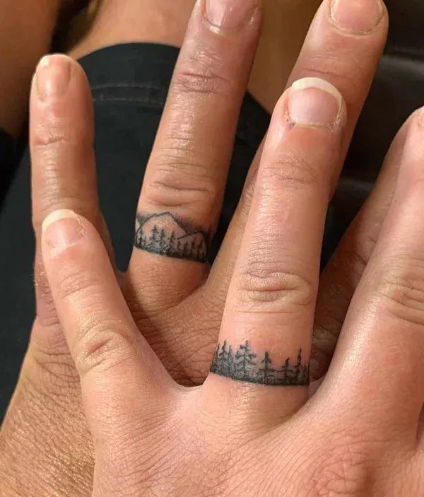 Ring finger tattoos featuring a mountain range and a pine forest landscape.