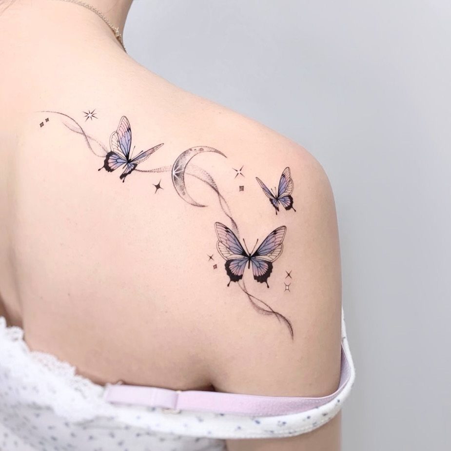 Butterfly and crescent moon tattoo with stars on a woman's shoulder